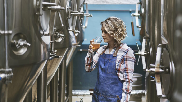 Brauerin testet frisch gebrautes Bier in Brauerei.