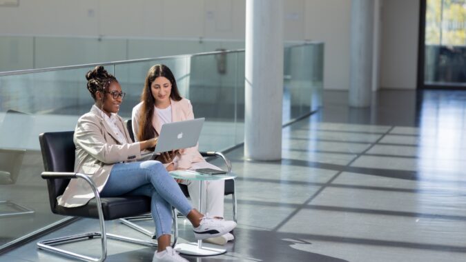 zwei Junge Frauen in einer Sitzgruppe mit Laptop