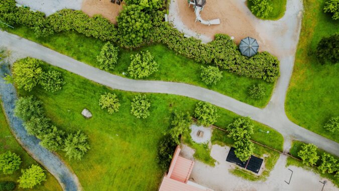 Eine Straße führt durch eine grüne Landschaft mit grünen Wiesen und Bäumen.