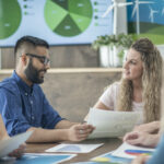 Work colleagues discuss trends in sustainable technologies.