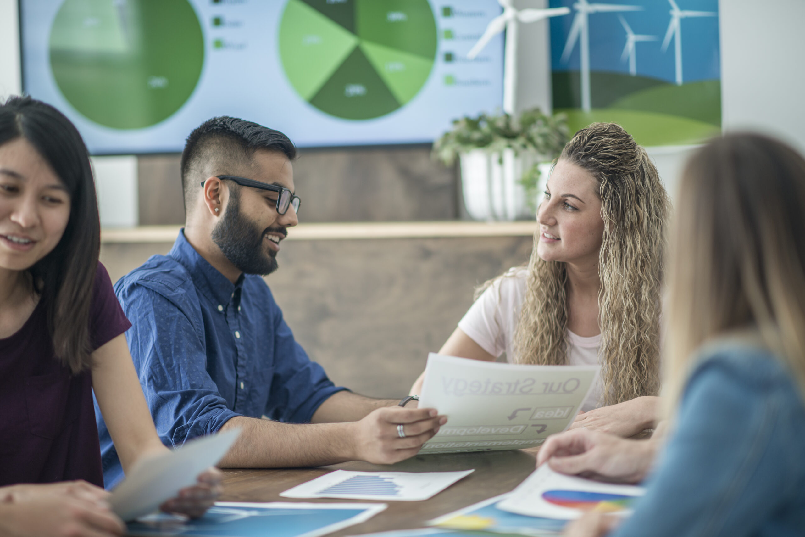 Work colleagues discuss trends in sustainable technologies.